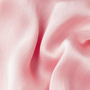 A close-up of soft pink draped fabric with a subtle sheen and fine texture, filling the entire frame, Obroi