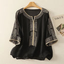 Black blouse with white embroidery on a hanger against a light background, Obroi