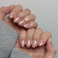 Close-up of a hand with beige nail polish on a neutral background, Obroi