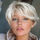 A close-up portrait of a woman with a short, layered platinum blonde wig or hairpiece against a soft gray background, Obroi