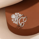 Silver butterfly-shaped ring with gemstones on a brown surface, Obroi