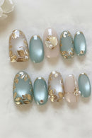 Set of nail art designs with gold leaf and pearl accents on a neutral background, Obroi