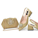 Gold glittery high-heeled shoes and matching handbag on a white background, Obroi
