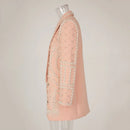 Pink coat with intricate beadwork on a mannequin against a plain background, Obroi