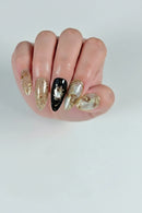 Close-up of hands with decorative nail art against a brown leather background, Obroi