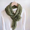 Green scarf draped over a mannequin with a white background, Obroi