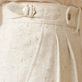 Close-up of a textured beige fabric with buttons on a beige background, Obroi