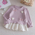 Children's outfit with pink ribbed sweater and white skirt on a textured surface, Obroi