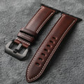 Brown leather watch strap with black buckle on a gray textured background, Obroi