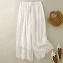 White lace-trimmed pants with a woven bag and white shoes on a beige background, Obroi