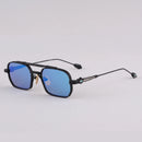 Sunglasses with blue lenses and black frames on a light gray background, Obroi