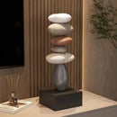 Decorative sculpture of stacked stones on a pedestal in a modern interior setting, Obroi