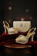 Pair of ornate high-heeled shoes with matching handbag on a dark background, Obroi
