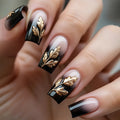 Nails with black and gold leaf design on a neutral background, Obroi
