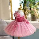 Pink children's dress on a mannequin with flowers in a home setting, Obroi