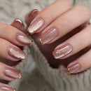 Close-up of hands with pink nail polish and gold accents on a blurred background, Obroi