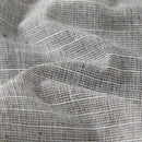 Close-up of a woven fabric with a black and white grid pattern, showing the texture and folds of the material, Obroi