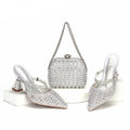 Silver high-heeled shoes and clutch bag with rhinestone details on a white background, Obroi