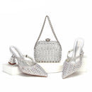 Silver high-heeled shoes and clutch bag with rhinestone details on a white background, Obroi