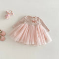 Pink children's dress with a bow on a light gray background, Obroi