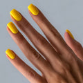 Hand with yellow nail polish on a gray background, Obroi