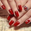 Close-up of hands with red nail polish on a textured surface, Obroi