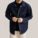 Person wearing a dark blue denim shirt on a plain background, Obroi