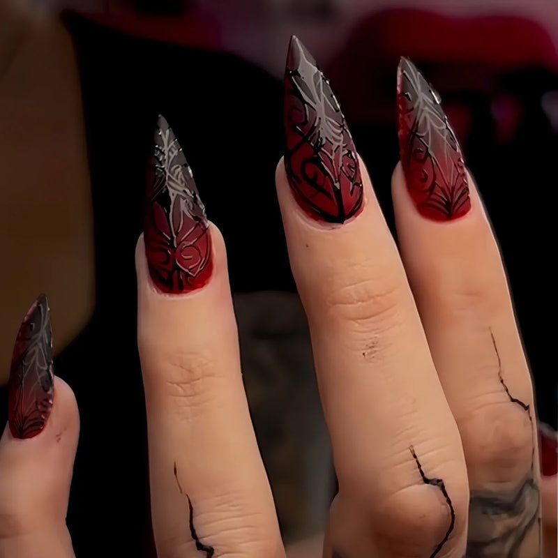 Obroi Close-up of hands with red and black nail art on a blurred background