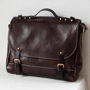 Brown leather bag with gold buckles on a white surface, Obroi
