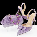 Purple high-heeled shoes with a matching handbag and jewelry set on a white background, Obroi