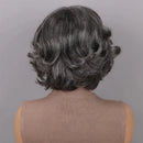 Back view of a person with short, styled hair against a gray background, Obroi