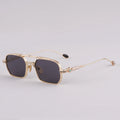 Gold-framed sunglasses with dark lenses on a light gray background, Obroi