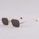 Gold-framed sunglasses with dark lenses on a light gray background, Obroi