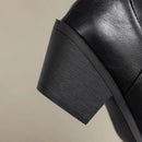 Close-up of a black leather shoe with a thick sole on a beige background, Obroi