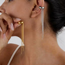 Close-up of a woman wearing gold and silver earrings with tassels, Obroi