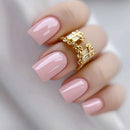 Pink nail polish on a hand with a gold ring against a neutral background, Obroi