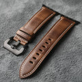 Brown leather watch strap with black buckle on a gray background, Obroi