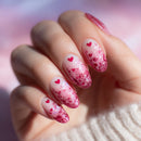 Hand with pink and red heart-shaped nail polish on a blurred background, Obroi
