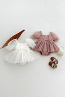 Two baby rompers, a pair of shoes, and a small bag on a light background, Obroi