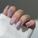 Hand with pink and holographic nails against a neutral background, Obroi