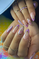Hand with pink and gold nail art on a colorful background, Obroi