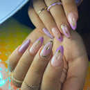Hand with pink and gold nail art on a colorful background, Obroi