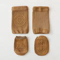 Set of brown baby booties with textured soles on a light gray background, Obroi
