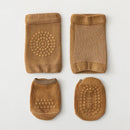Set of brown baby booties with textured soles on a light gray background, Obroi