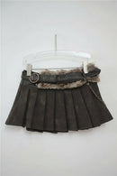 Dark gray pleated skirt with fur trim and belt on a hanger against a light gray background, Obroi