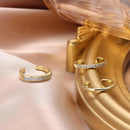 Gold rings on a pink fabric with a gold container in the background, Obroi
