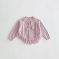 Pink knitted sweater with tassels on a light gray background, Obroi