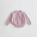 Pink knitted sweater with tassels on a light gray background, Obroi