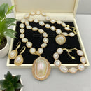 Jewelry set including necklace, earrings, and bracelet in a box with plants in the background, Obroi