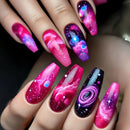 Nails with galaxy design in pink, purple, and blue on a hand, Obroi